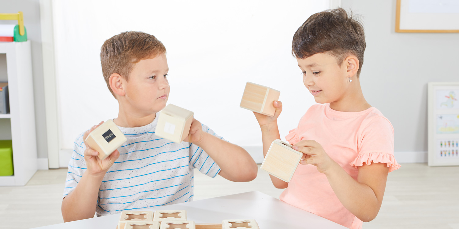 Kinder spielen gemeinsam mit den Akustikwürfeln und versuchen alle Klangpaare zu finden.